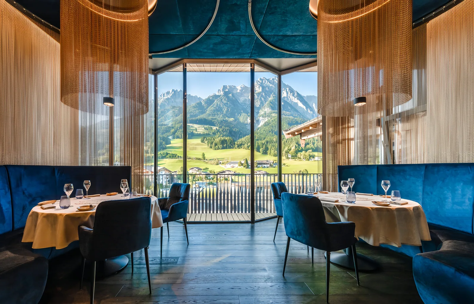 Chain curtain drapery in a hotel restaurant interior with warm metallic hanging panels