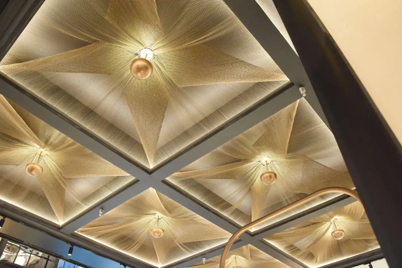 SGORIA architectural metal mesh ceiling feature with warm lighting